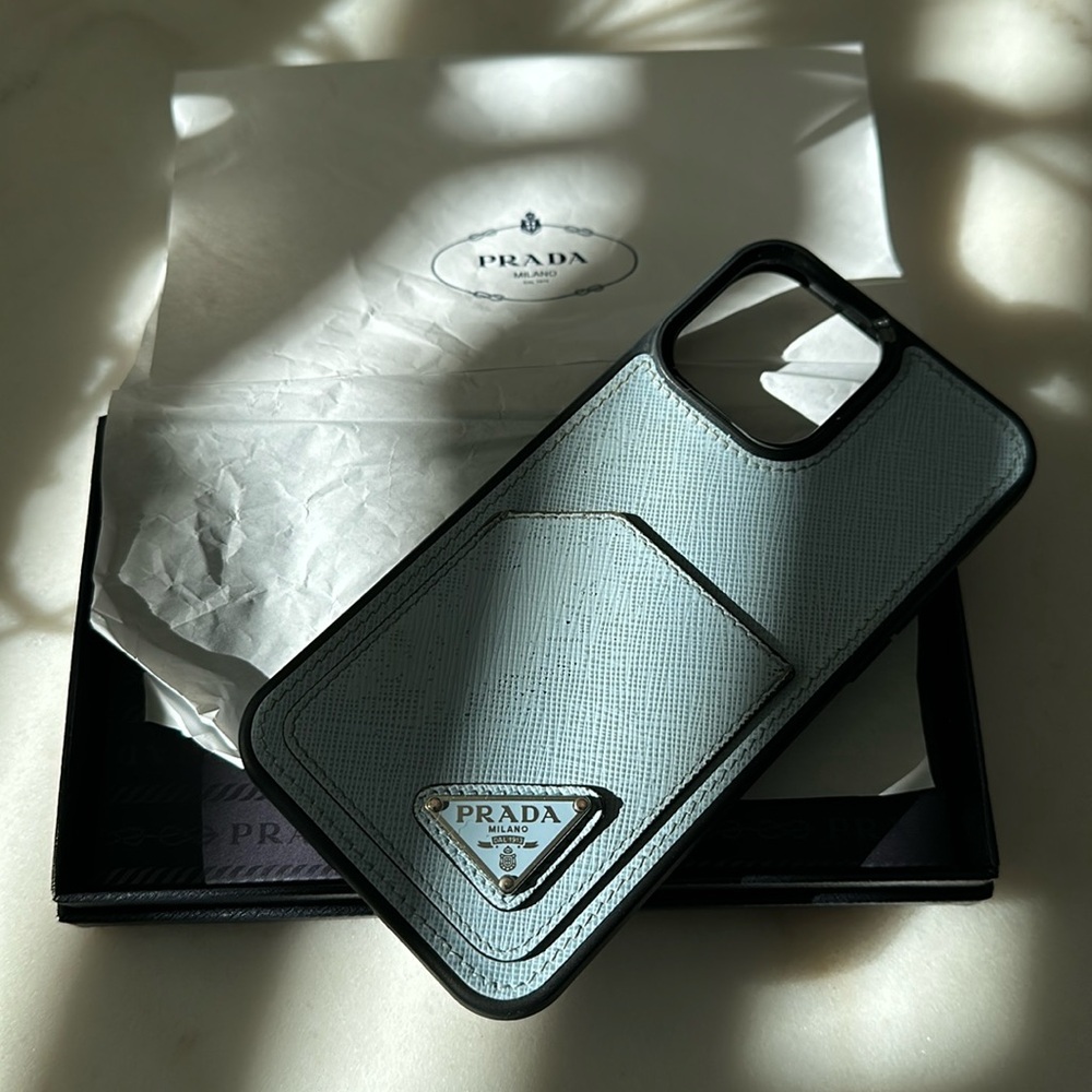 Prada phone case for IPhone 14 ProMax - ice blue color with pocket on back.